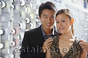 Asia Images Group - Couple standing in wine cellar, looking at camera, portrait