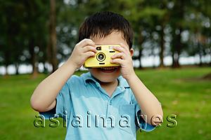 Asia Images Group - Young boy taking pictures with yellow camera