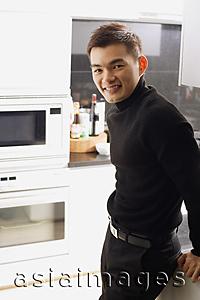 Asia Images Group - Man in kitchen, looking at camera
