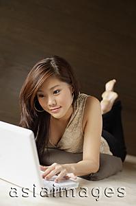 Asia Images Group - Woman lying on floor, using laptop