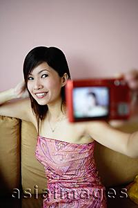 Asia Images Group - Woman using camera to take photo of herself