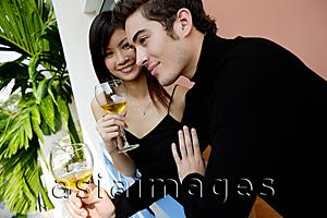 Asia Images Group - Couple standing in balcony with wine glasses