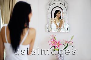 Asia Images Group - Woman applying make-up with brush, looking into mirror