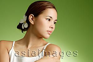 Asia Images Group - Young woman, flower in hair, looking away