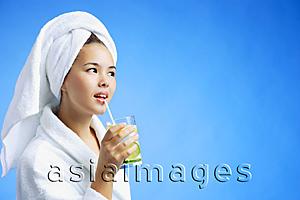 Asia Images Group - Young woman wearing white bathrobe and towel turban, drinking