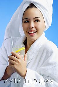 Asia Images Group - Young woman wearing white bathrobe and towel turban, with drink