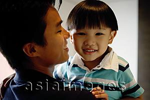 Asia Images Group - Young boy carried by dad, looking at camera