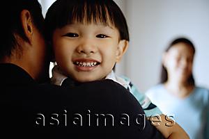 Asia Images Group - Young boy looking over father's shoulder