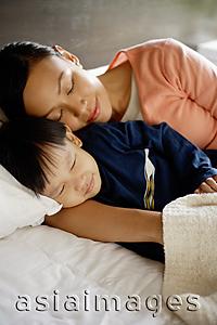 Asia Images Group - Mother and son sleeping on bed