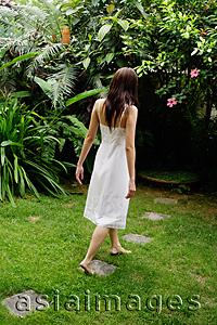 Asia Images Group - Woman in white dress walking in garden