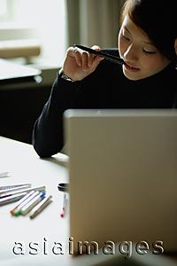 Asia Images Group - Female designer with pen in mouth