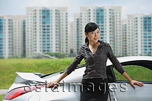 Asia Images Group - Woman standing next to silver sports car, looking at camera, smiling