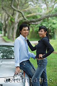 Asia Images Group - Couple next to car, looking at camera