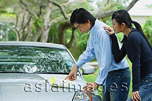 Asia Images Group - Couple looking a map on hood of car