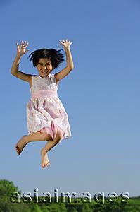 Asia Images Group - Girl in pink dress, jumping in mid air, smiling at camera