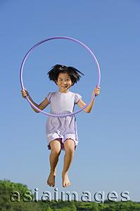Asia Images Group - Girl in lavender dress, jumping in mid air, holding hoop