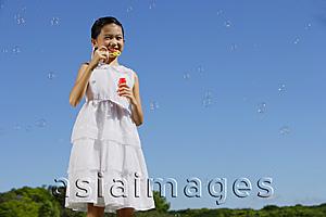 Asia Images Group - Girl in white dress, blowing bubbles