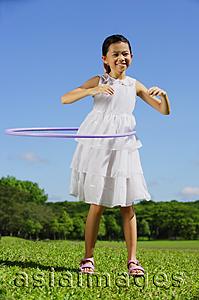 Asia Images Group - Girl in park using hoola hoop