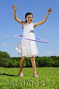 Asia Images Group - Girl in park playing with hoola hoop