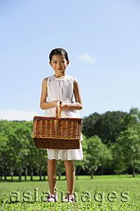 Asia Images Group - Girl in white dress, holding picnic basket