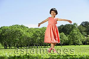 Asia Images Group - Girl walking on grass, arms outstretched, smiling