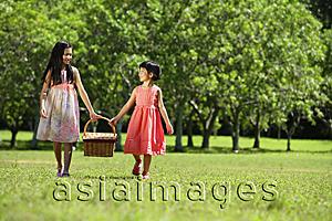 Asia Images Group - Girls walking in park, carrying picnic basket