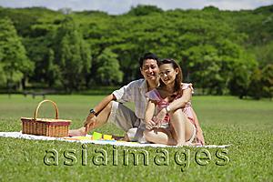 Asia Images Group - Couple sitting in park, having a picnic, looking at camera