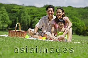 Asia Images Group - Family of three having a picnic, looking at camera