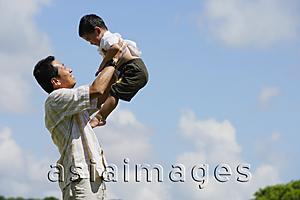 Asia Images Group - Father lifting son in the air, side view