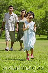 Asia Images Group - Family with one child walking in park, daughter running in foreground