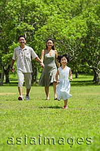 Asia Images Group - Mother and father holding hands, walking, daughter running in foreground