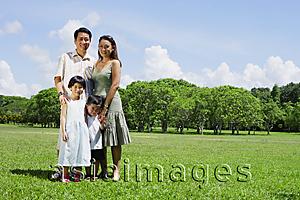 Asia Images Group - Family of four standing in field, looking at camera