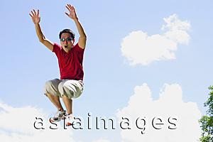 Asia Images Group - Man jumping in mid air, arms outstretched, mouth open