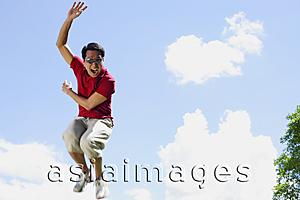 Asia Images Group - Man jumping in mid air, hand raised, mouth open