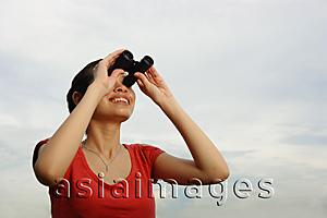 Asia Images Group - Woman using binoculars, smiling