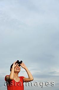 Asia Images Group - Woman looking through binoculars, smiling