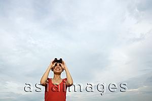 Asia Images Group - Woman with binoculars looking at sky