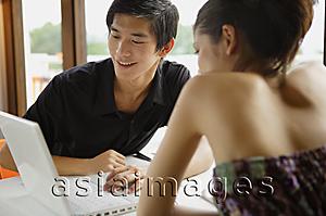 Asia Images Group - Couple in restaurant, looking at laptop