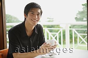 Asia Images Group - Man in cafe having coffee
