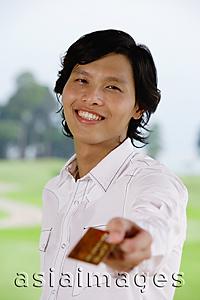 Asia Images Group - Man holding credit card, towards camera, smiling