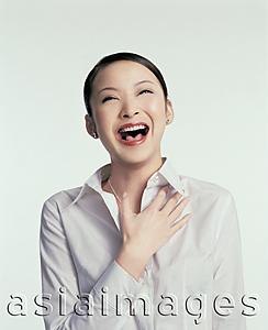 Asia Images Group - Young woman laughing, hand on chest