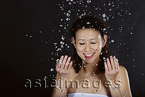 Asia Images Group - Woman splashing her face with water