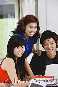 Asia Images Group - Teenagers with laptop and books, smiling at camera, portrait