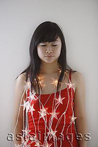 Asia Images Group - Young woman with eyes closed, wearing fairy lights