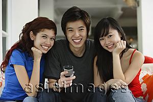 Asia Images Group - Teenagers sitting side by side, smiling at camera, portrait