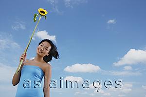 Asia Images Group - Woman holding sunflower stalk