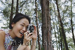 Asia Images Group - Young woman outdoors, taking a photograph