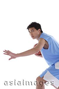 Asia Images Group - Young man playing basketball, arm outstretched
