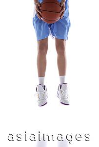 Asia Images Group - Young man jumping, holding basketball, low section, cropped image