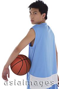 Asia Images Group - Young man with basketball, looking over shoulder